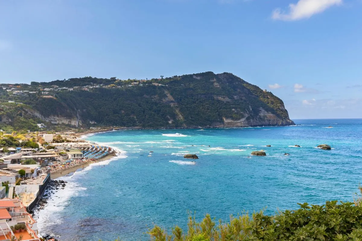 Veduta della baia con spiaggia, promontorio verde e mare turchese
