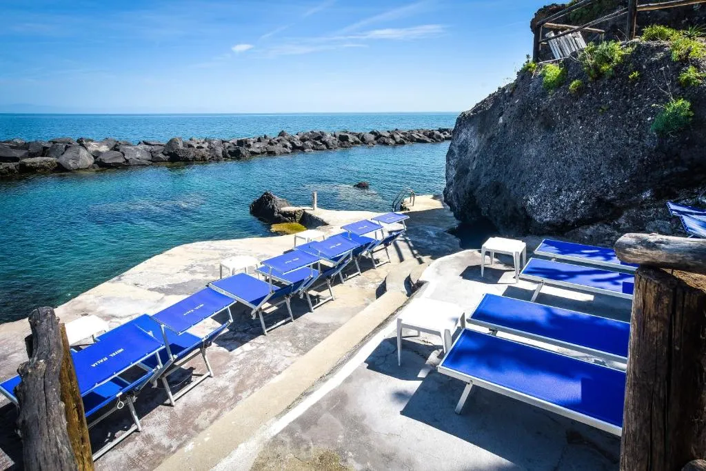 Lettini blu sulla piattaforma rocciosa con vista sul mare e frangiflutti