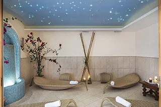 Area relax della spa con lettini, soffitto stellato e atmosfera rilassante