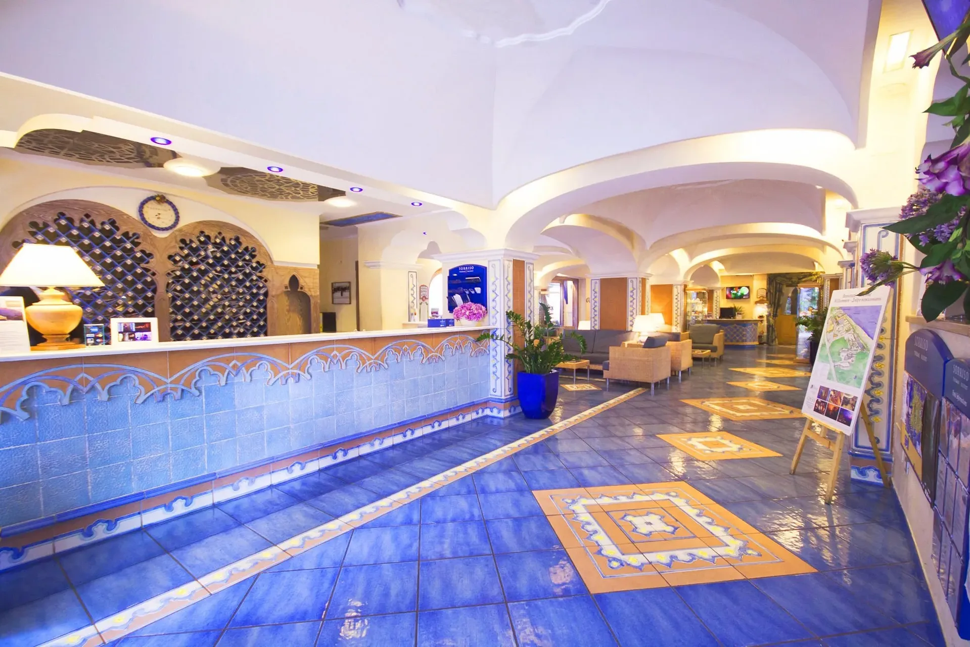 Hall del resort con pavimento in ceramica blu decorata e reception in stile mediterraneo