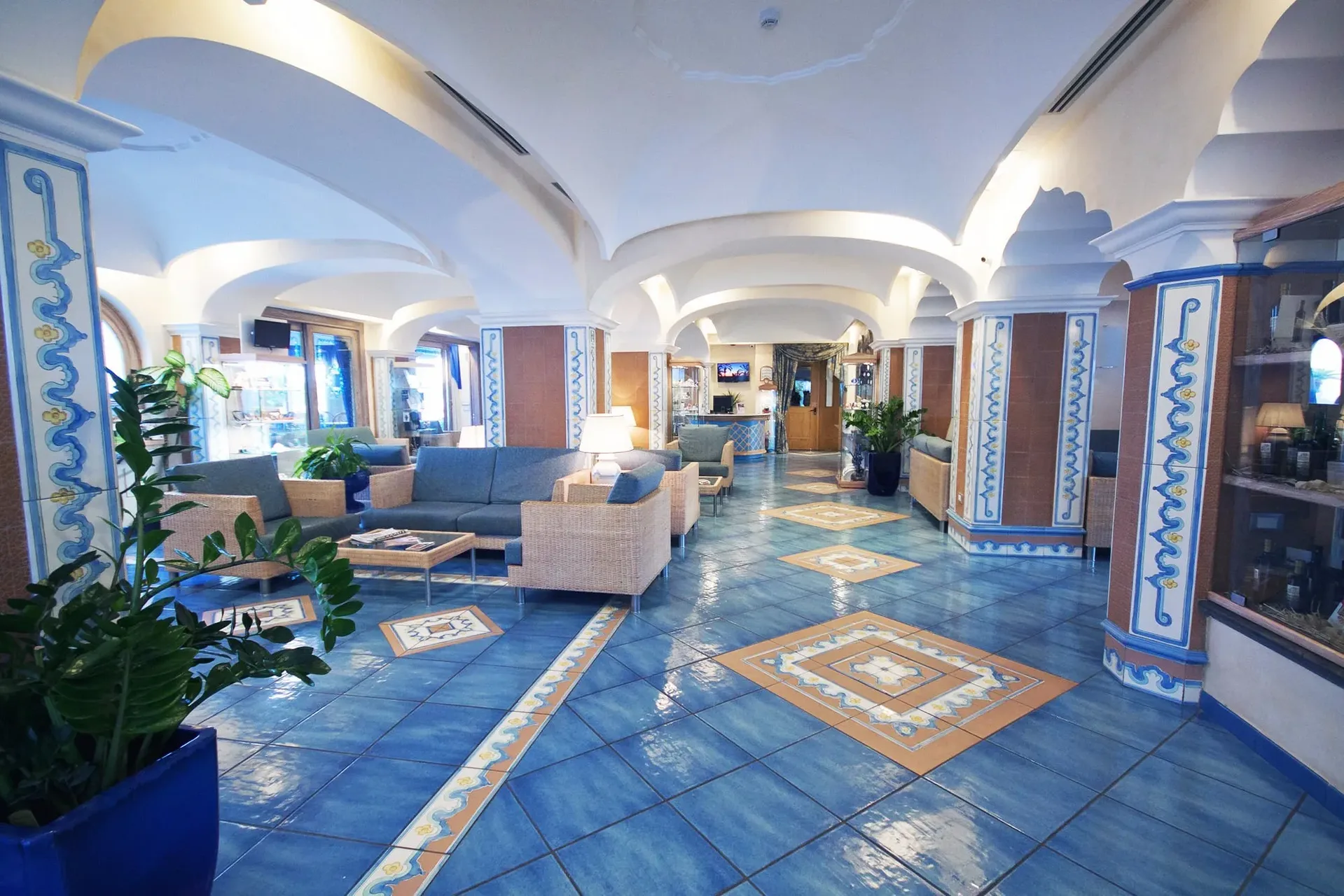 Ampia hall con colonne decorate, divani e pavimento in maiolica blu tradizionale